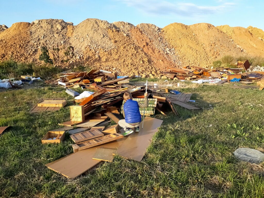 A child play among the rubble of a dumpster.